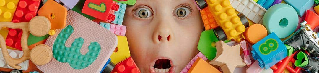 visage enfant désorganisé au travers d'un tas de jouet